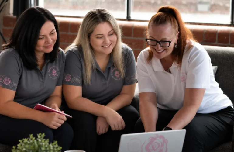 Three BelRose Group team members working together around a laptop