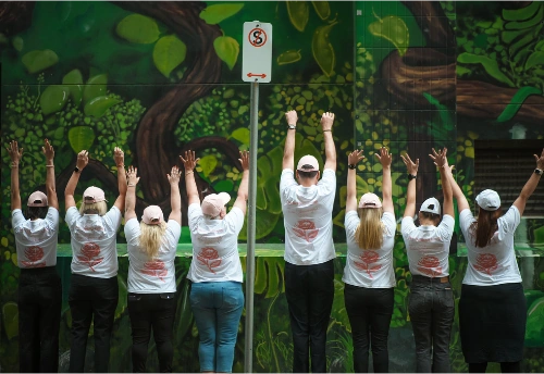 Eight BelRose team members together with their hands raised